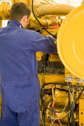 A technician performing periodic engine maintenance in a landfill gas recovery plant